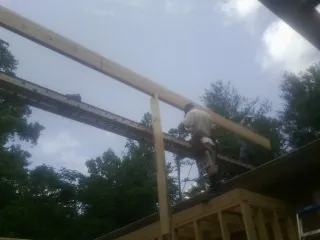 Carpenter setting a ridge beam over a new addition frame — Ice Dam Removal by Roofing Brothers in Red Lion