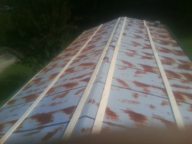 Rusted metal roof panels with new wood purlins before replacement — Storm Damage Roof Repair in Red Lion by Roofing Brothers