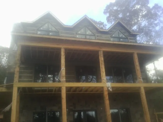 Dormers and porch framing on a large log home under construction — Roof Coating work by our crew in Red Lion
