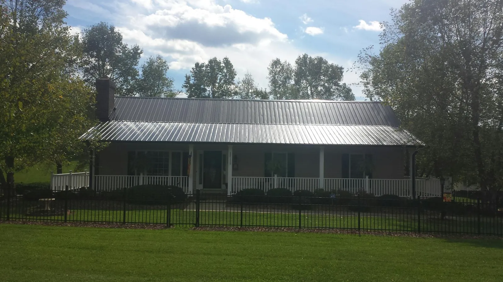 Gray metal roof on a brick ranch with a full width front porch — Gutter Guard Installation work by our crew in Red Lion